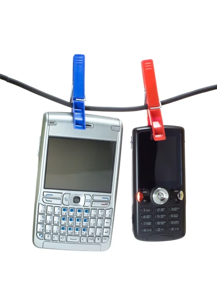Dois telefones celulares em uma linha de roupa — Fotografia de Stock