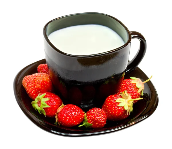 Black cup with milk and strawberries — Stock Photo, Image