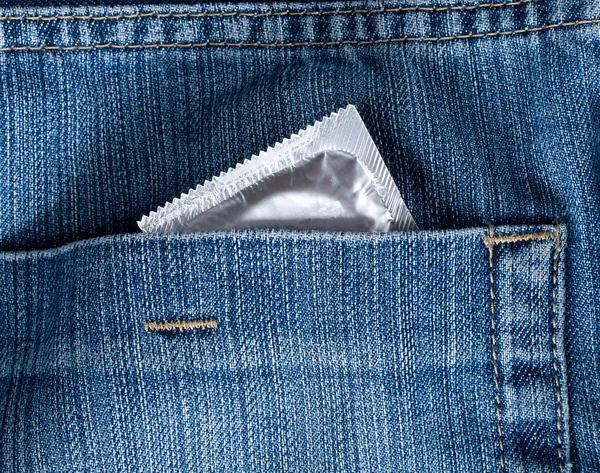 Blue jeans hip-pocket with condom in it — Stock Photo, Image