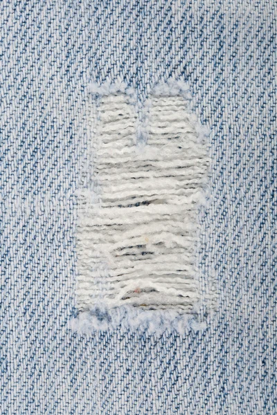 Close-up grande buraco em jeans velhos — Fotografia de Stock