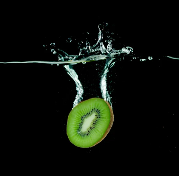 Kiwi spadající do vody na černém pozadí — Stock fotografie