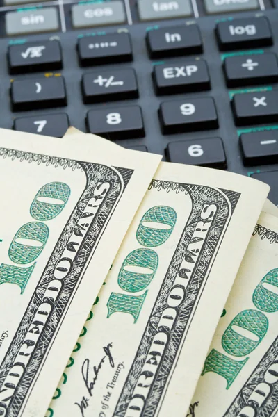 Muitos dólares sobre calculadora — Fotografia de Stock
