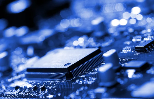 Microchip on blue circuit board — Stock Photo, Image