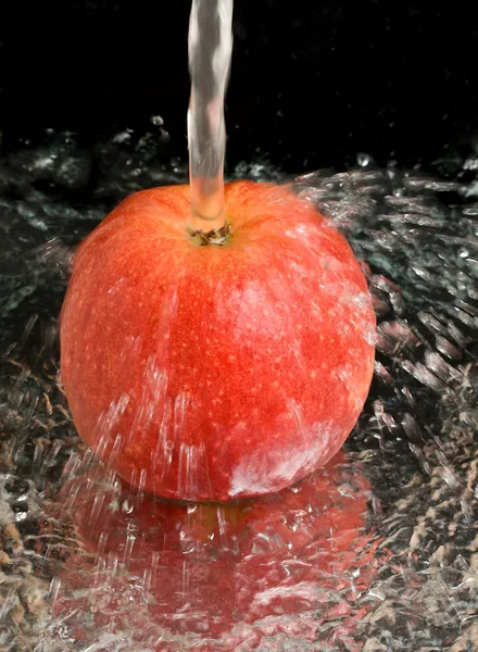 Red apple under water stream — Stock Photo, Image