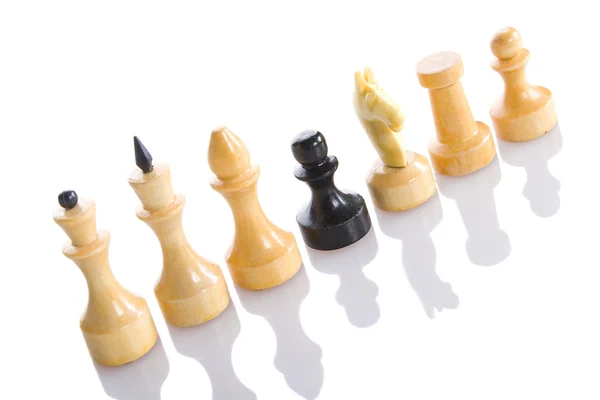 Bílé šachové figurky a jeden černý — Stock fotografie