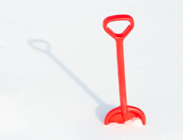 Red childrens shovel into a snow — Stock Photo, Image