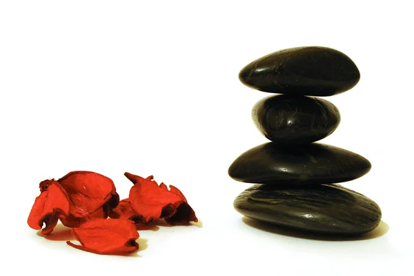 Spa stenen en rode bloemblaadjes — Stockfoto