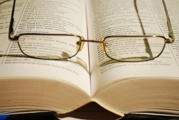 Óculos no livro — Fotografia de Stock
