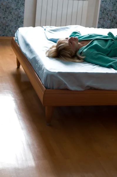 Kobieta leżąca na łóżku — Zdjęcie stockowe