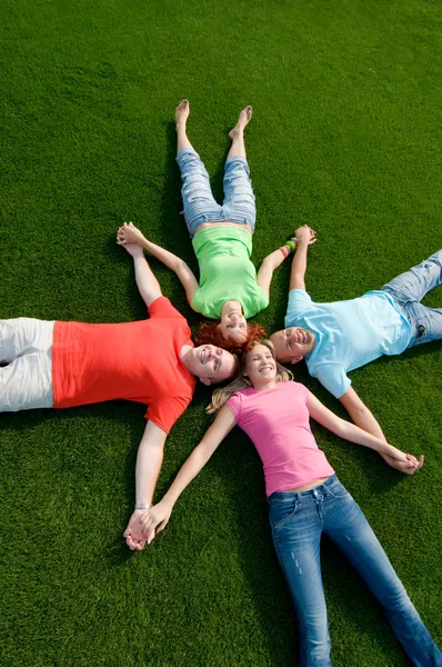Przyjaciele, leżąc na trawie — Zdjęcie stockowe