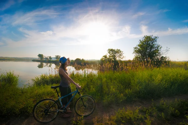 Девушка катается на велосипеде на рассвете — стоковое фото