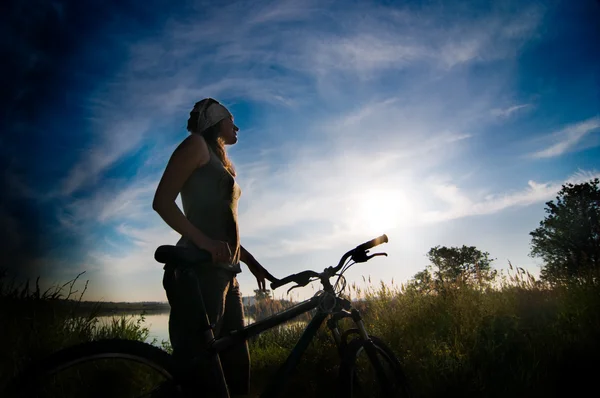 日出的时候骑自行车的女孩 — 图库照片