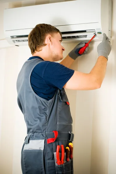 Man reparatie airconditioners Stockafbeelding