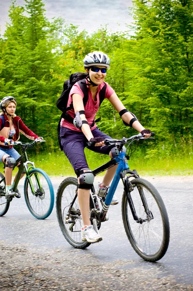 Две девушки на велосипеде — стоковое фото