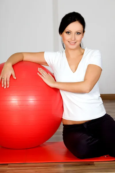 Jovem mulher sorridente, com bola de fitness — Fotografia de Stock