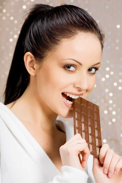 Schöne Frau isst Schokolade Stockfoto