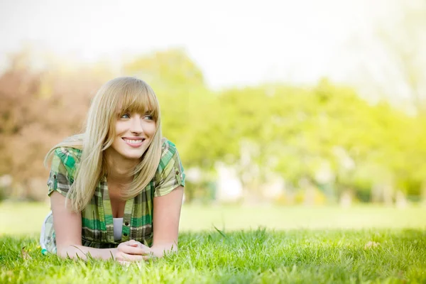 Donna sorridente sdraiata sull'erba — Foto Stock