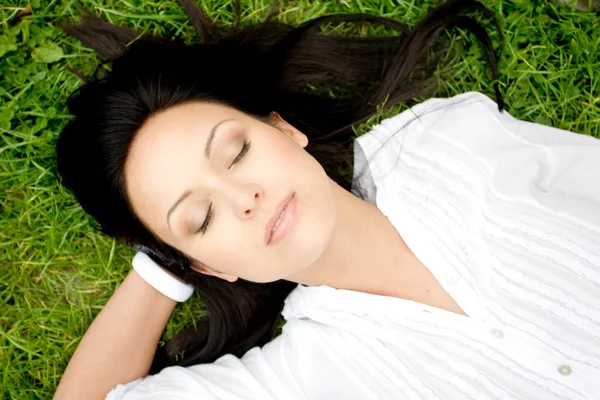Beautiful woman laying on grass — Stock Photo, Image
