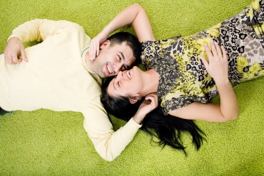 Happy couple laying on carpet clipart