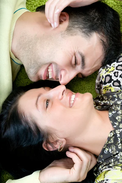 Jovem casal feliz deitado no chão — Fotografia de Stock