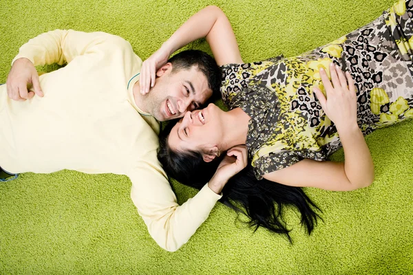 Счастливая пара, лежащая на ковре — стоковое фото