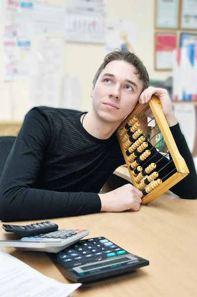 stock image Young man thinks and calculates the acco