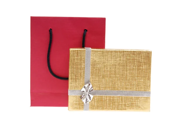 Красный бумажный пакет и золотой подарочный коробок с луком — стоковое фото