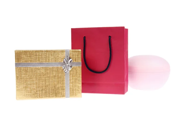 Red paper bag and gold gift box with bow — Stock Photo, Image