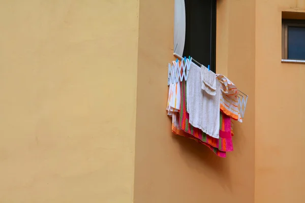 洗衣吊在一个窗口 — 图库照片
