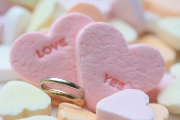 Свадебные кольца и конфетные сердца — стоковое фото