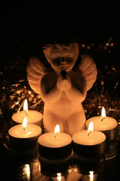 Ángel de Navidad y luces votivas — Foto de Stock
