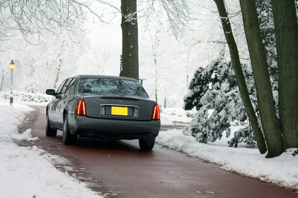 在冬季道路上灰色轿车 免版税图库图片