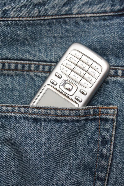 Мобильный телефон в джинсовом кармане — стоковое фото
