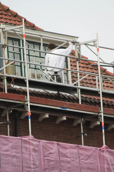 Painter at work on scaffold — Stock Photo, Image