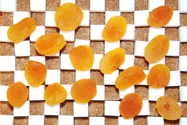 Cubes of sugar and dry apricots — Stock Photo, Image