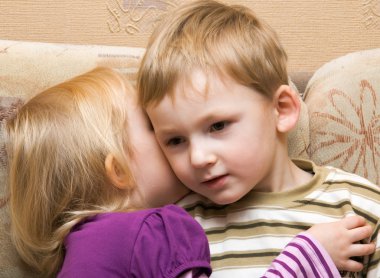 Young boy and girl are whispered clipart