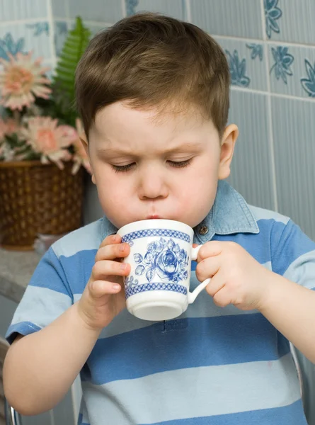 Kind trinkt aus einer Tasse — Stockfoto
