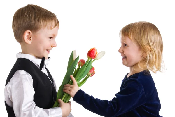 Netter Junge gibt Tulpen an Mädchen — Stockfoto