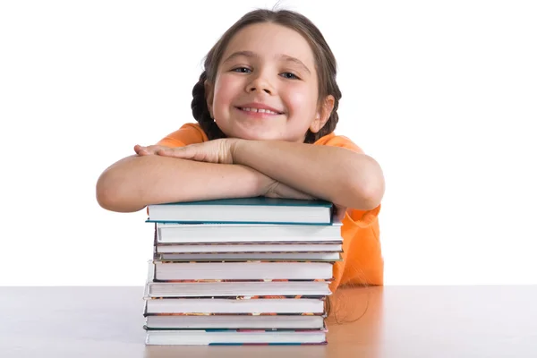 Молодая школьница с грудой книг — стоковое фото