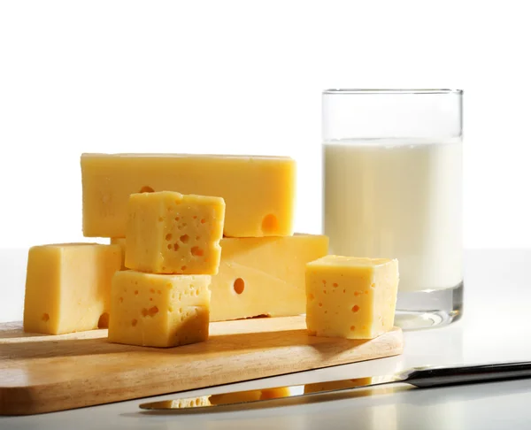 Käsestücke und Milchglas — Stockfoto