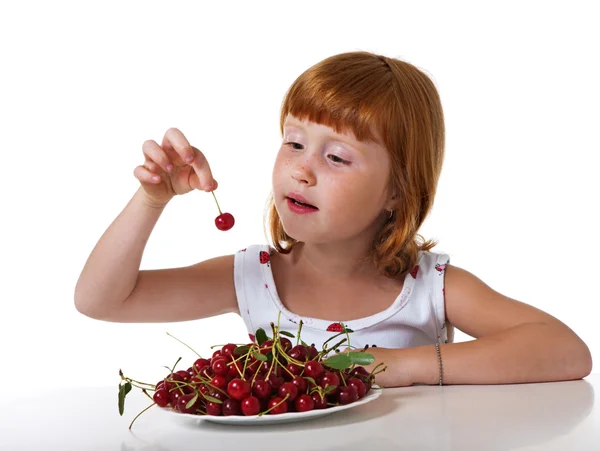 Redheaded little girl with cherry Stock Photo