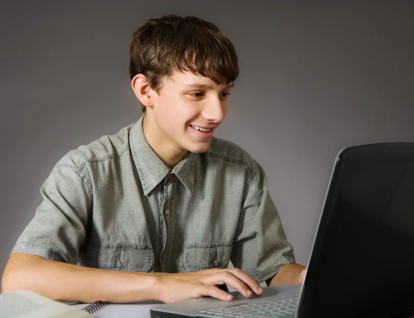Teenage boy uses laptop — Stock Photo, Image