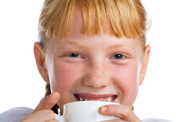 Roodharige meisje met een beker melk — Stockfoto