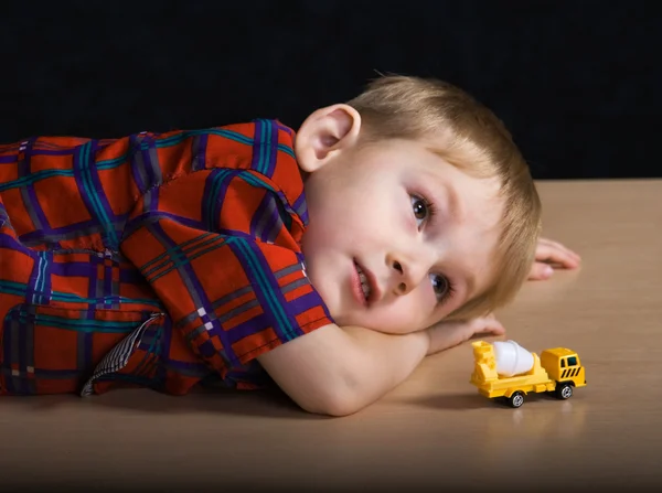 Усміхнена дитина з іграшковою машиною — стокове фото