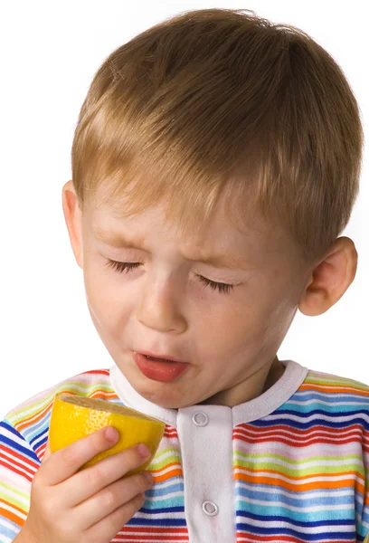 Ребенок ест лимон — стоковое фото
