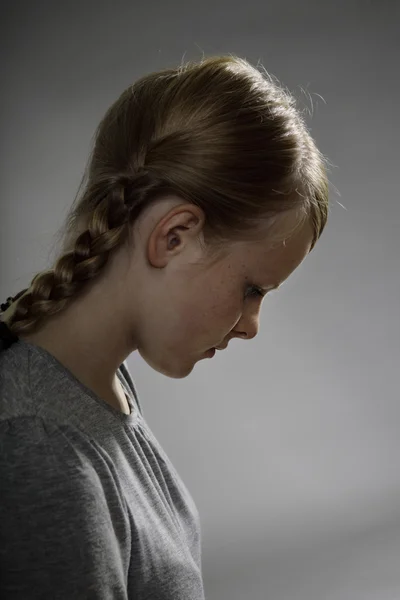 Einsames Teenager-Mädchen auf grauem Hintergrund — Stockfoto