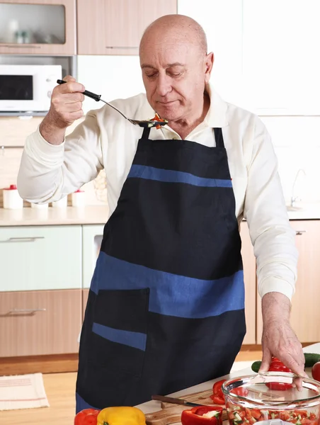 Senior man tasting from spoon — Stock Photo, Image