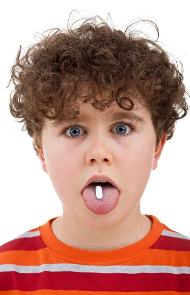 Junge mit Tablette auf der Zunge — Stockfoto