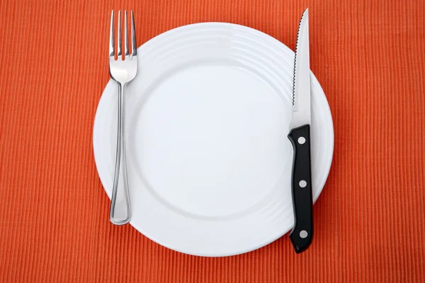 Empty plate on orange background — Stock Photo, Image