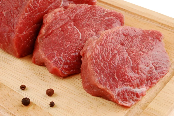 Carne cruda isolata sul tagliere — Foto Stock